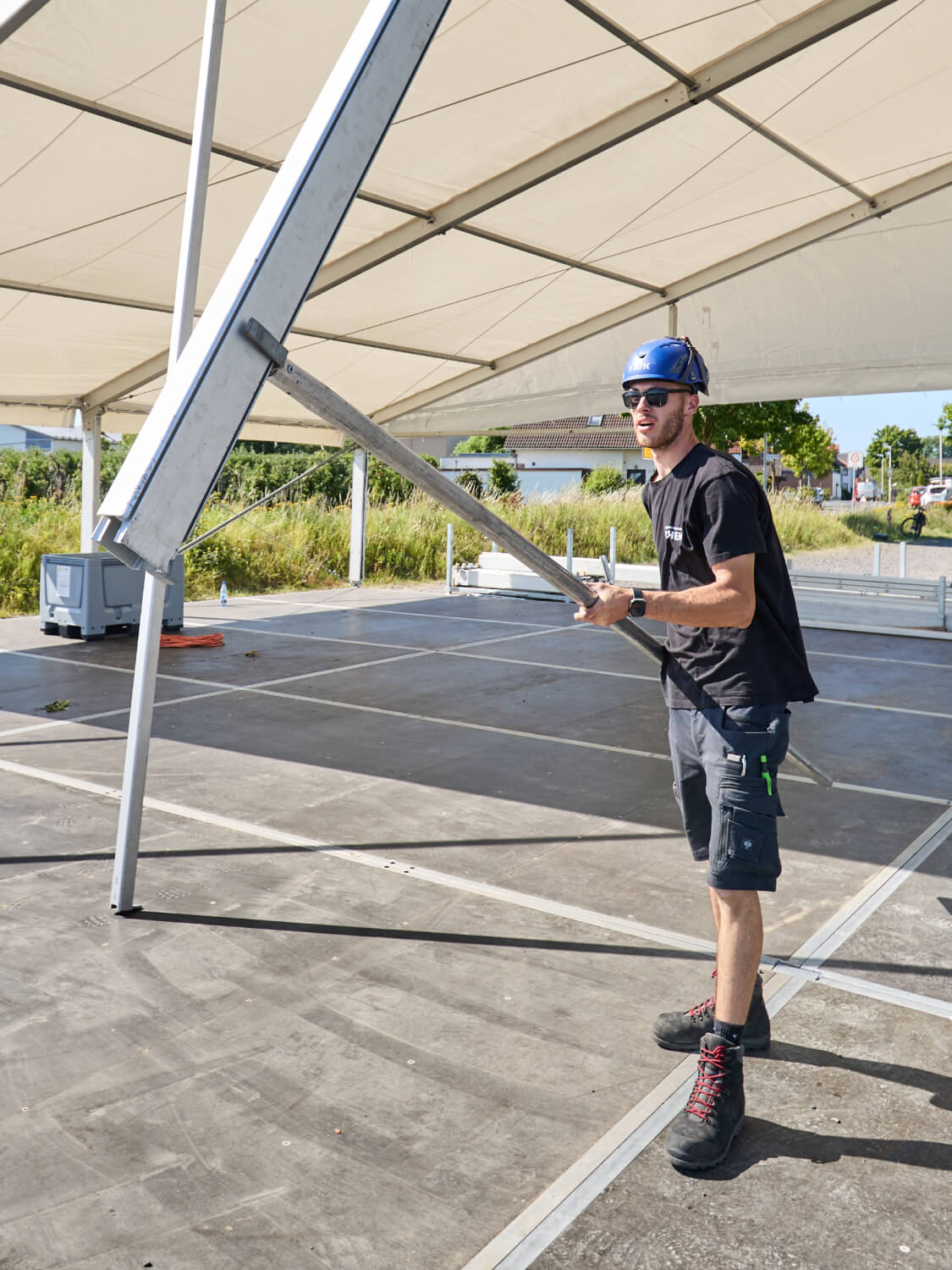 Mitarbeiter montiert das Gestänge eines großen Zeltes