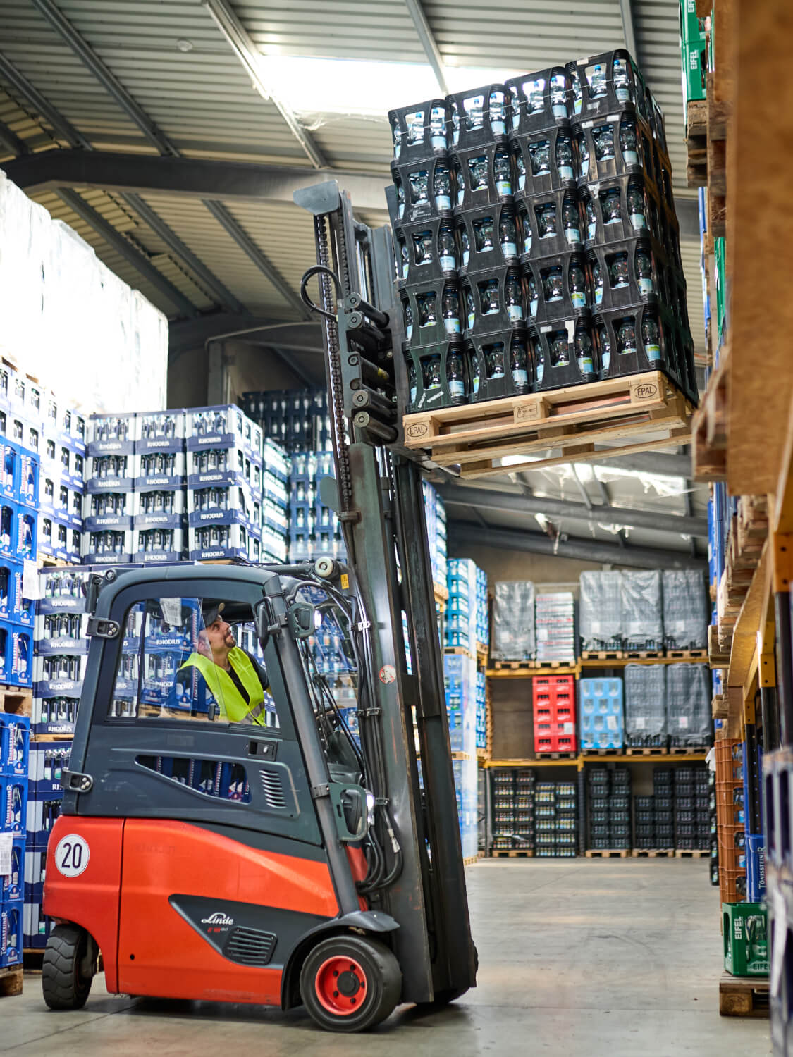 Gabelstaplerfahrer transportiert Getränkekisten im Lager