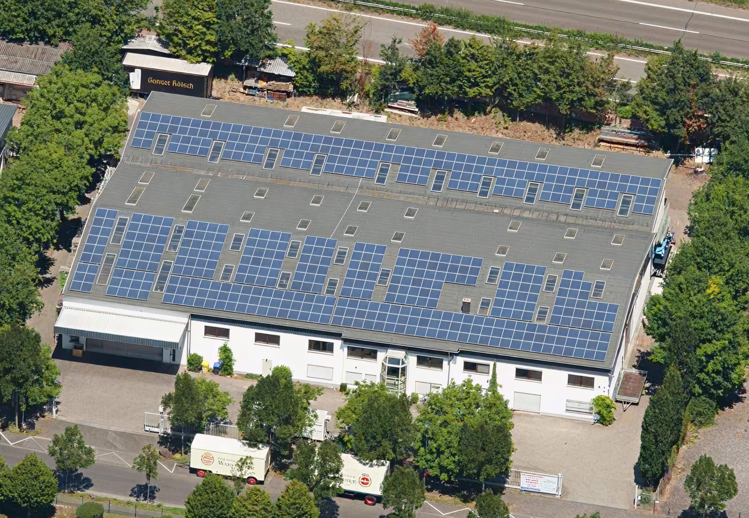 Luftaufnahme eines Gebäudes mit Solaranlage auf dem Dach