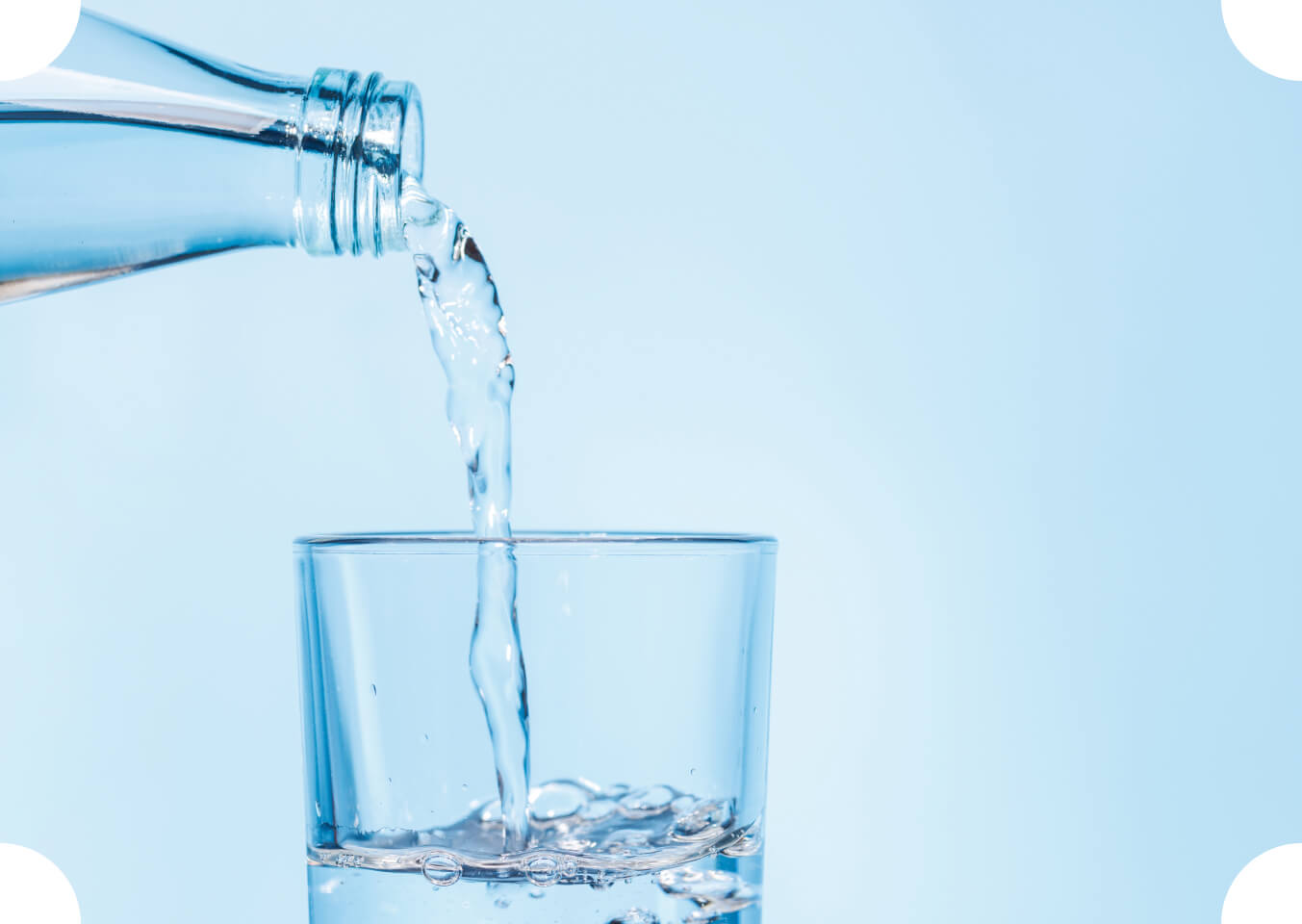Wasser wird aus einer Flasche in ein Glas gegossen