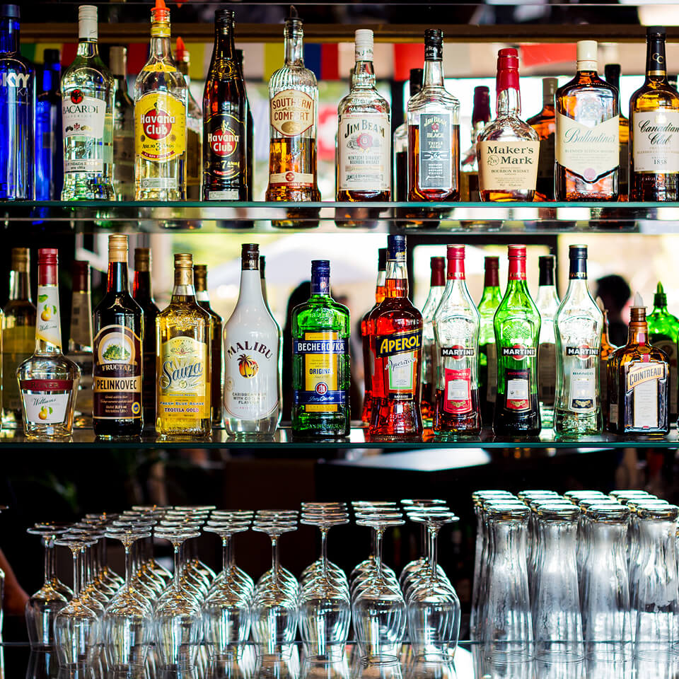 Großes Spirituosenregal mit verschiedenen Flaschen und Gläsern