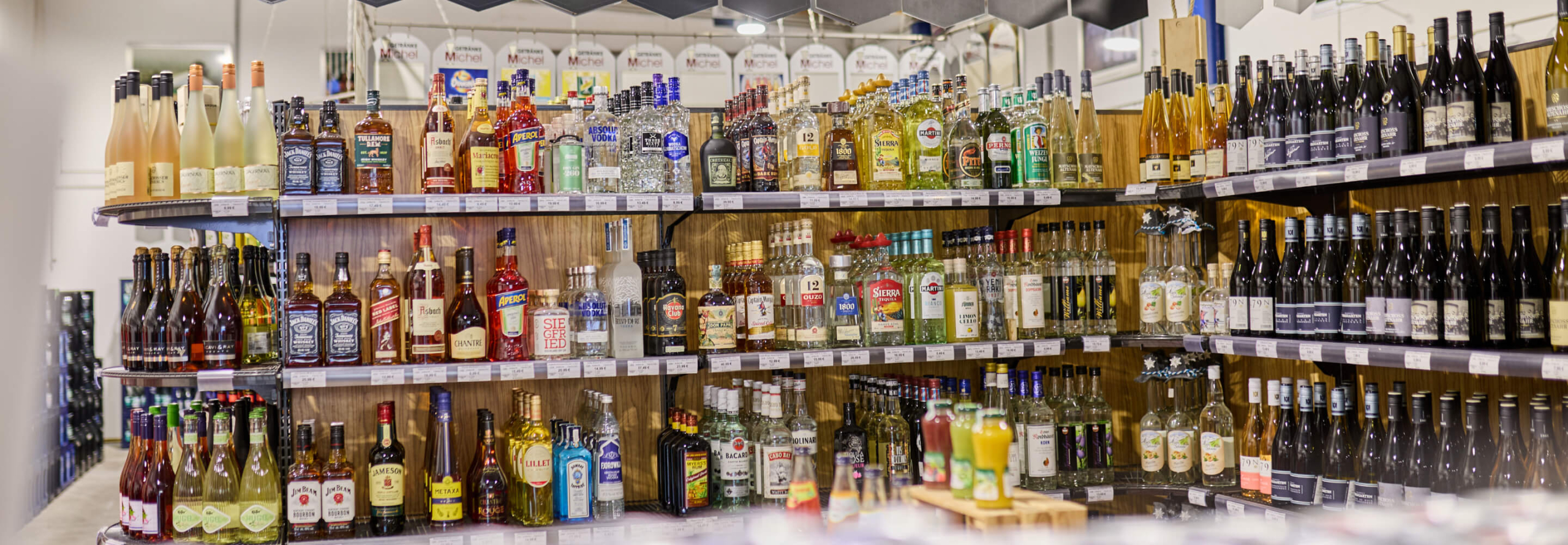 Großes Spirituosen- und Saftsortiment in einem Verkaufsregal
