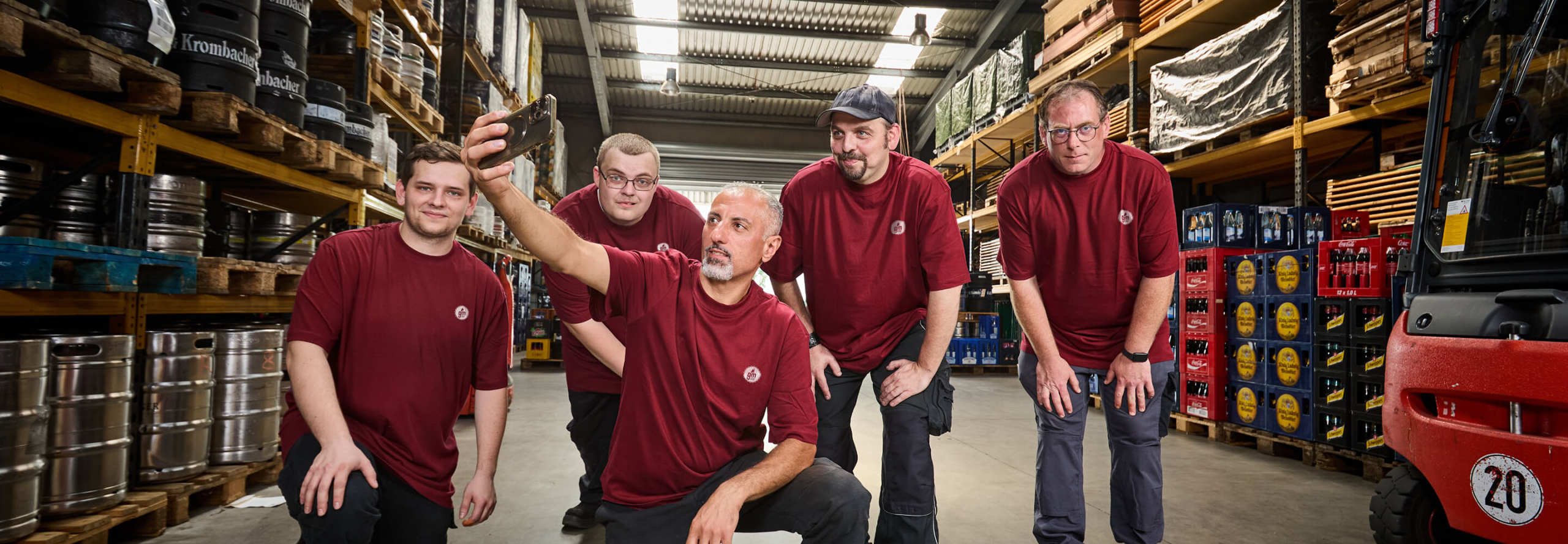 Mitarbeitergruppe macht ein Selfie im Getränkelager