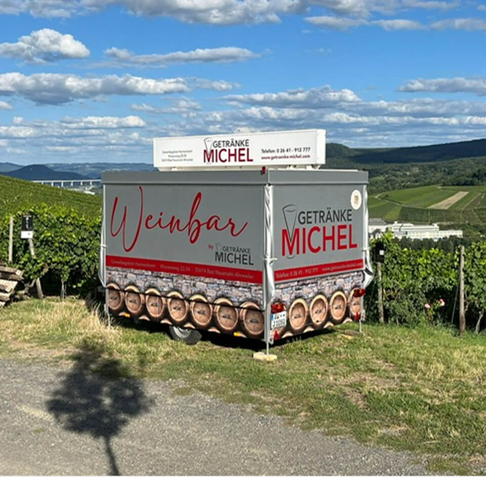 Weinbar-Container von Getränke Michel vor Landschaftskulisse