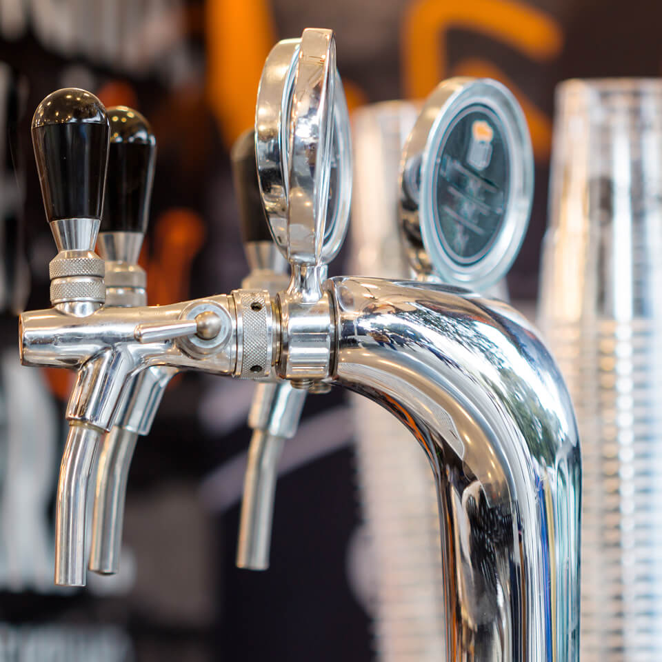 Nahaufnahme einer glänzenden Zapfanlage im Ausschankbereich