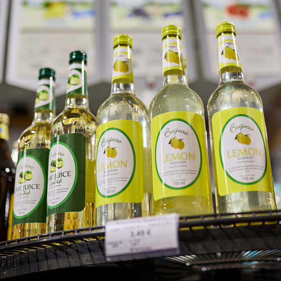 Glasflaschen mit Limonade und Saft im Verkaufsregal